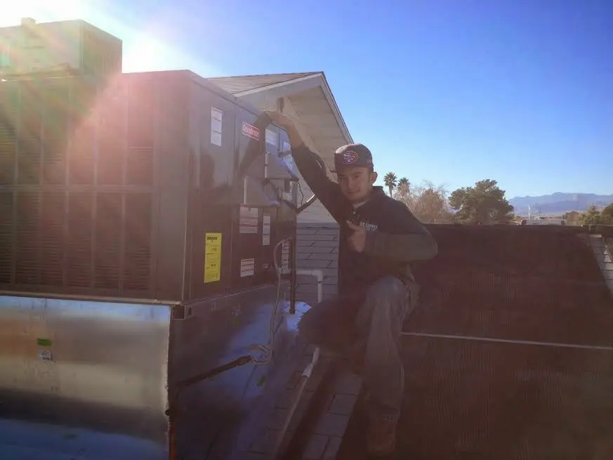 HVAC technician performing Boiler Repair on a rooftop unit in Wasco